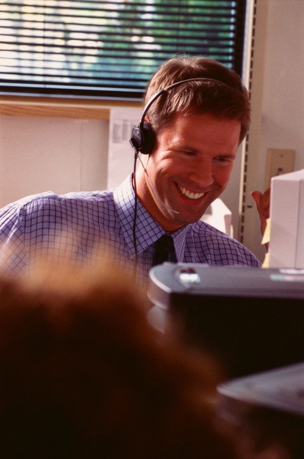 a man smiling while on a call